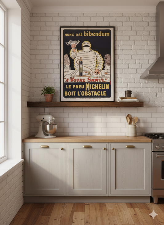 A wooden shelf above the counter holds a potted plant, a mug, and books. A vintage Michelin poster with the Michelin Man holding a trophy is framed on the wall above the shelf.