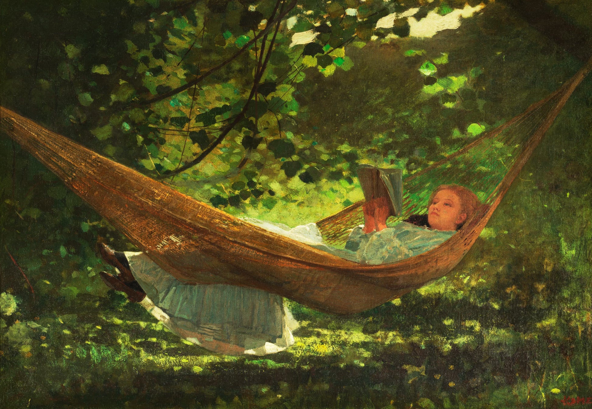 Woman reading a book in a hammock surrounded by greenery