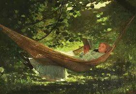 Person in a hammock with a dog in a forest setting