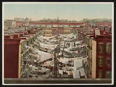 Vintage photograph of laundry hanging between buildings in an urban setting