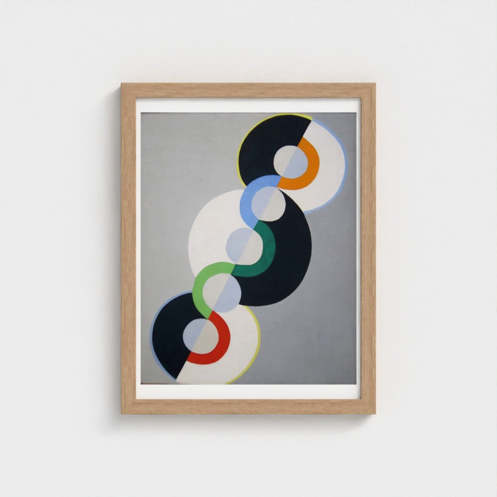 Framed abstract art print with colorful circular design on a gray background