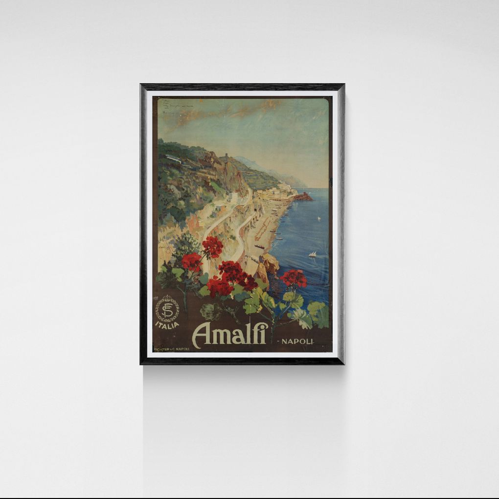 Framed artwork of Amalfi Coast with scenic view and flowers on a white wall.