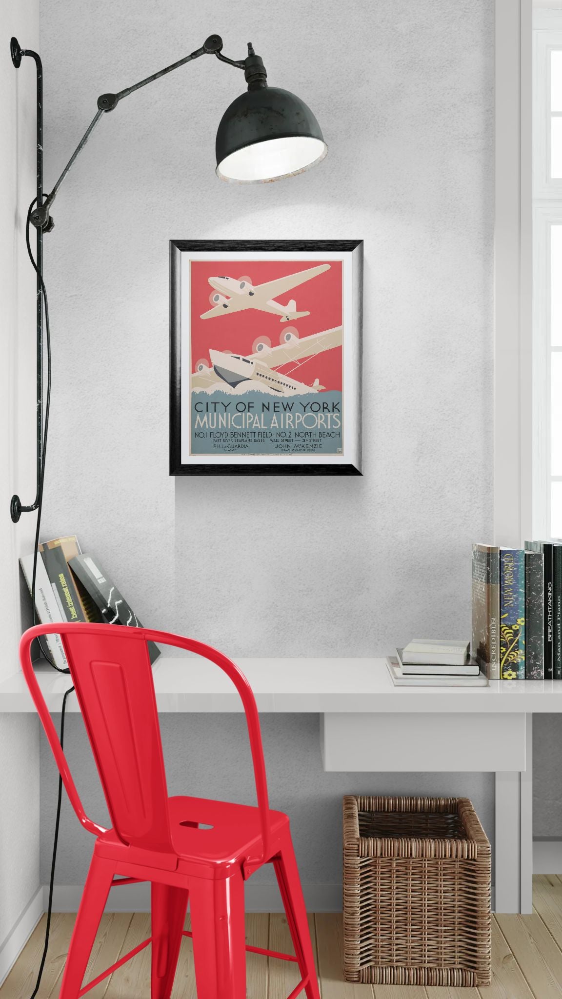 Red chair in front of a desk with a framed poster on the wall