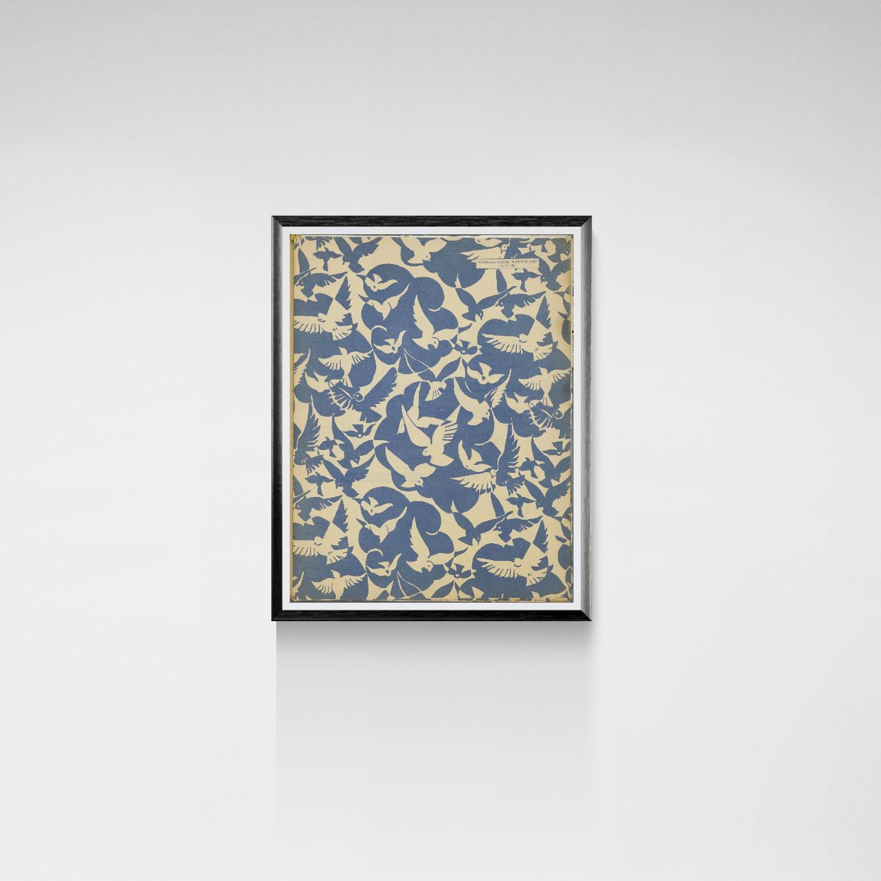 Framed artwork with a pattern of birds on a white wall