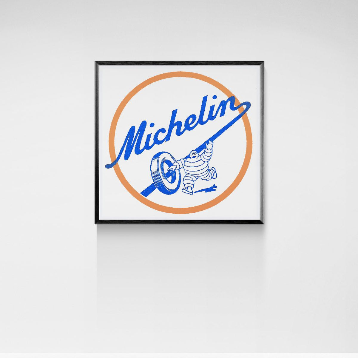 Framed Michelin logo with a character on a white wall