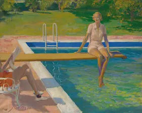 Woman sitting on a diving board over a pool with a grassy area and trees in the background.