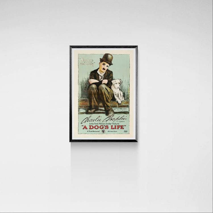 Framed poster of Charlie Chaplin and a dog on a white wall