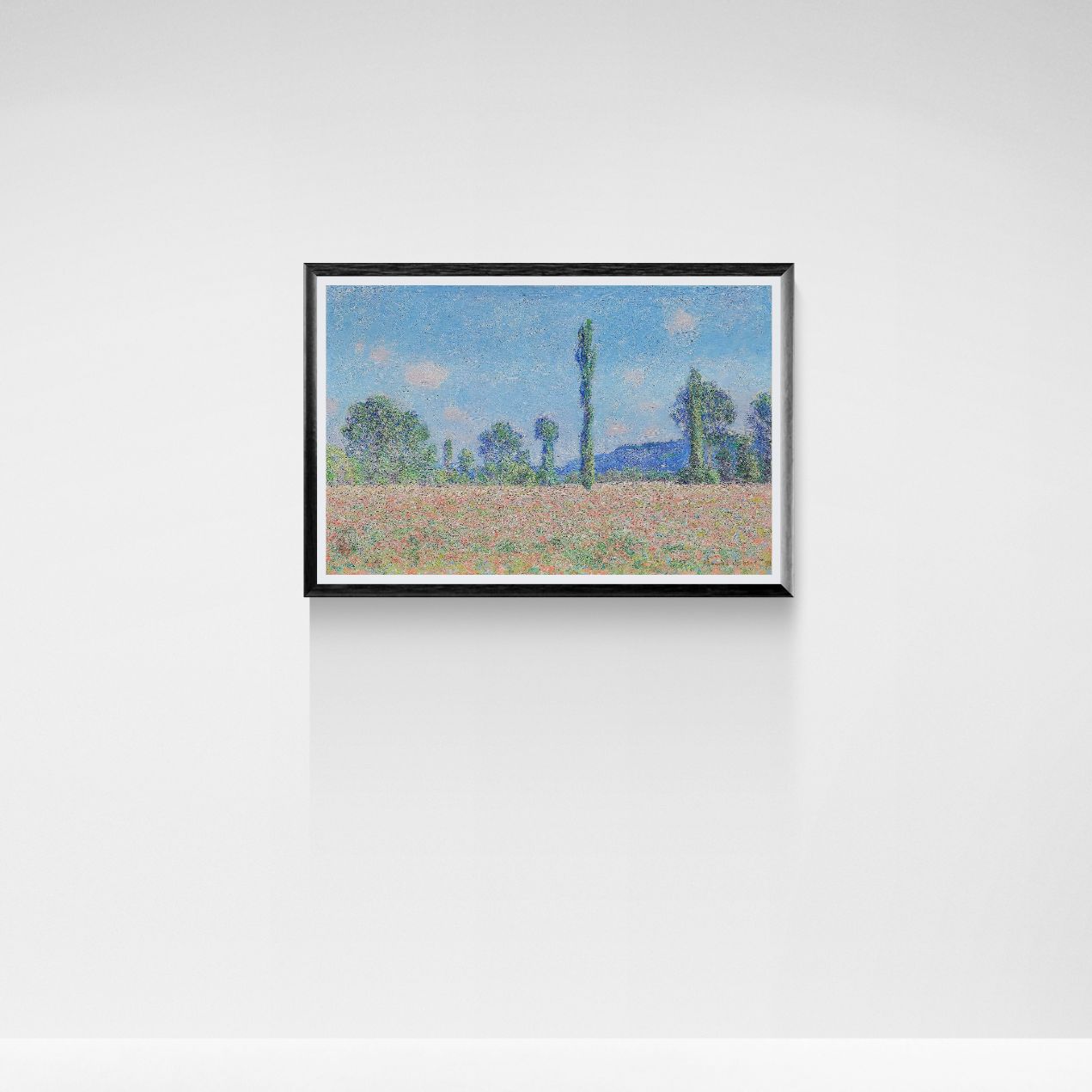 Framed artwork of a landscape with trees and sky on a white wall.