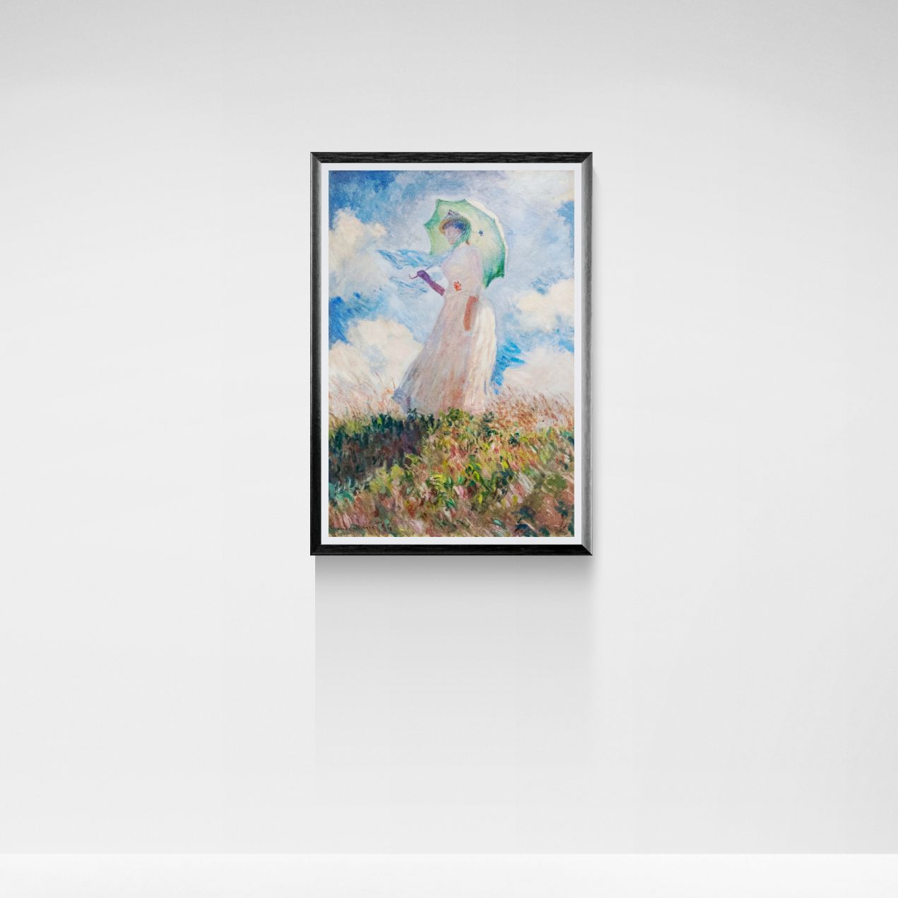 Framed artwork of a person with an umbrella against a cloudy sky on a white wall.