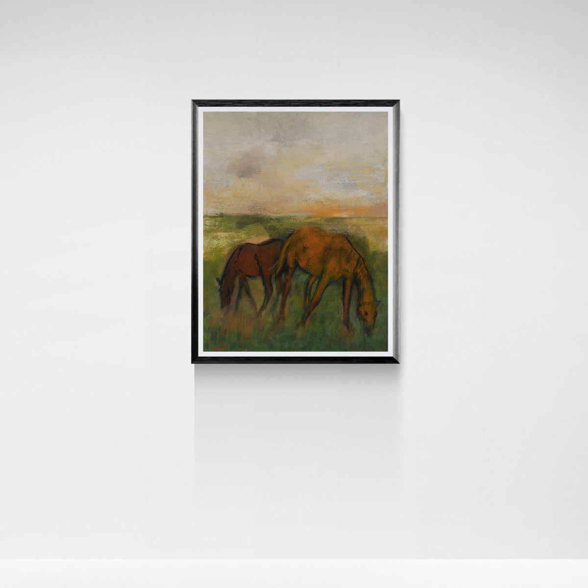 Framed painting of two horses grazing in a field with a sunset sky.