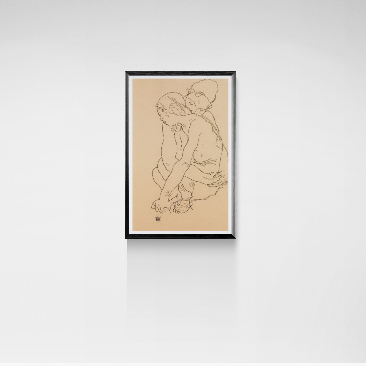 Framed Egon Schiele artwork of an embracing couple on beige paper against a white wall