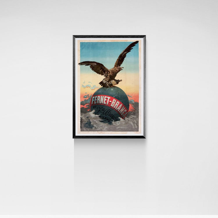 Framed artwork of an eagle on a globe with 'Fernet-Brand' text against a white wall.