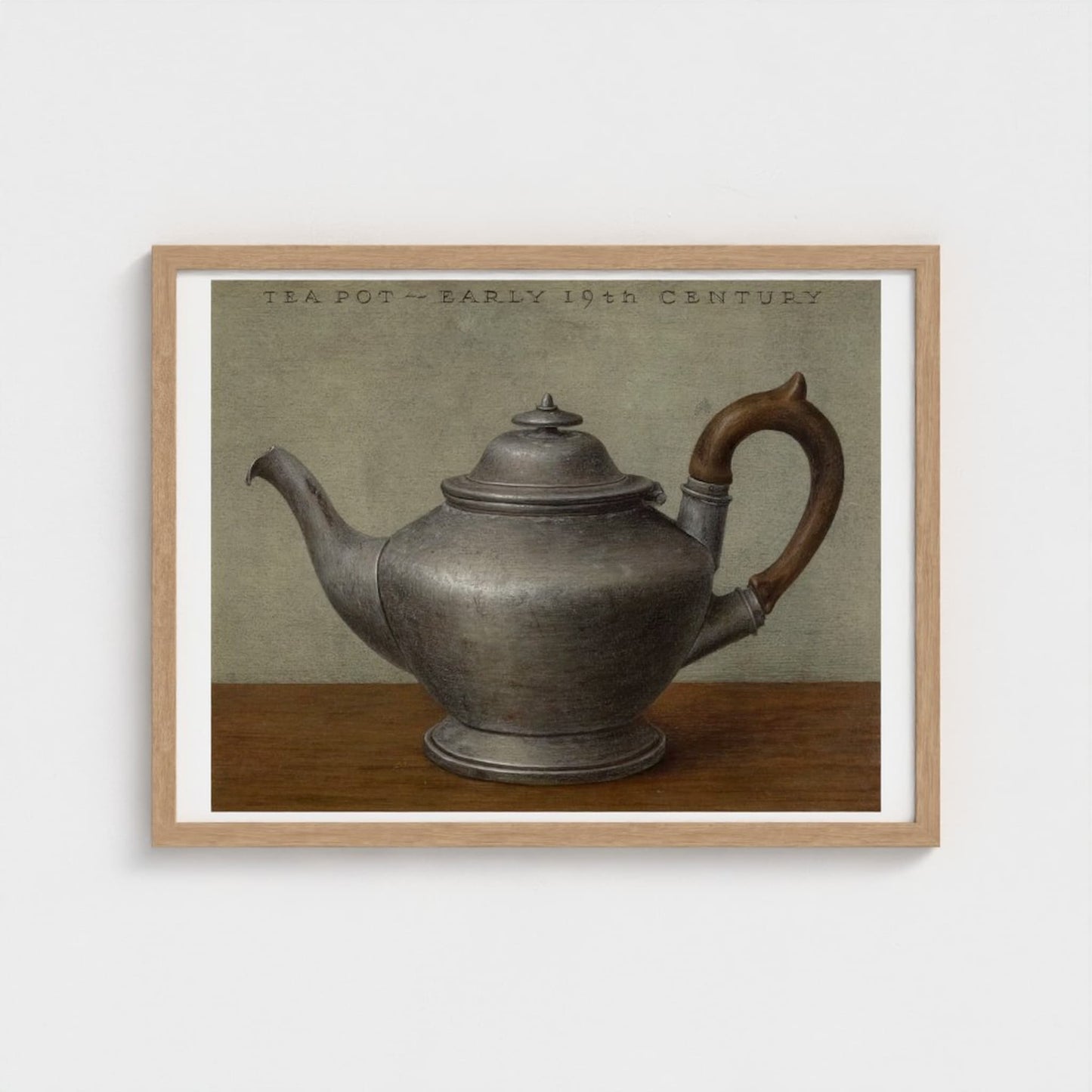 Framed artwork of a silver teapot on a wooden surface with a neutral background