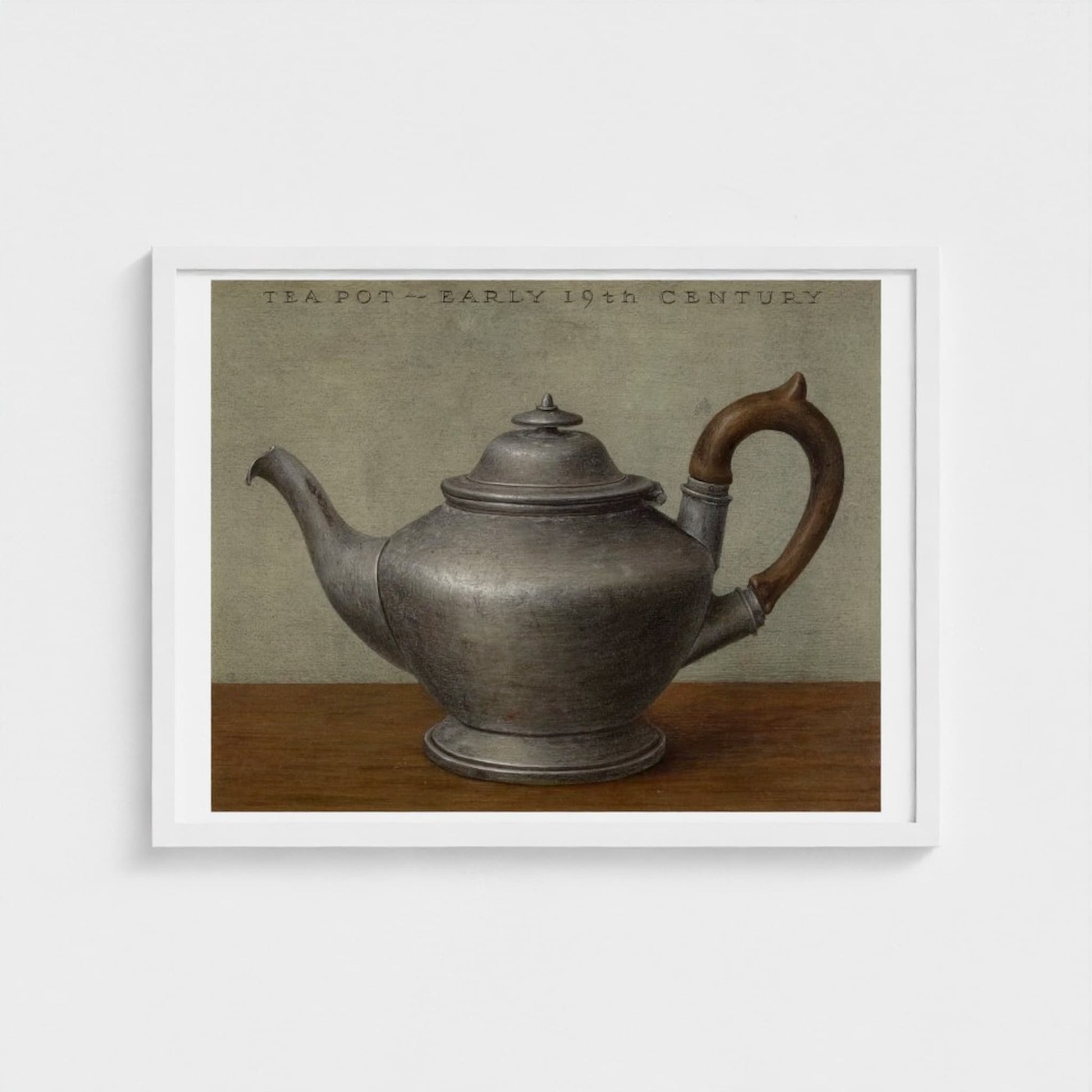 Framed artwork of an early 19th century teapot on a wooden surface with a neutral background.