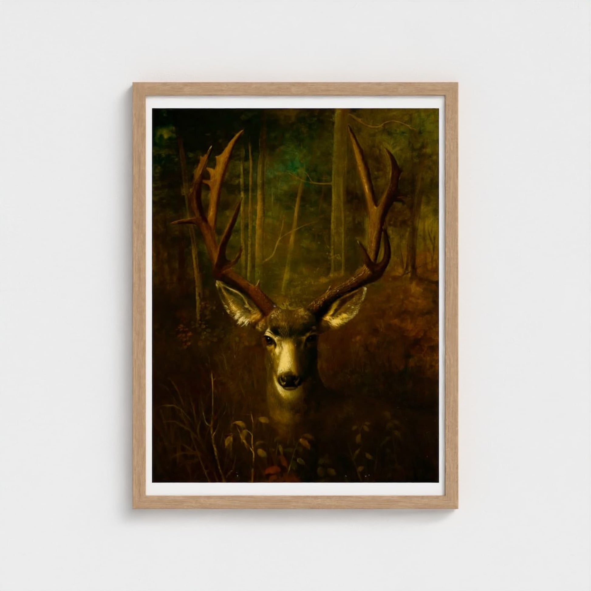 Framed artwork of a deer in a forest setting on a white wall.