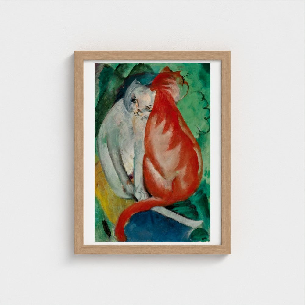 Framed artwork of two cats in a wooden frame on a white wall