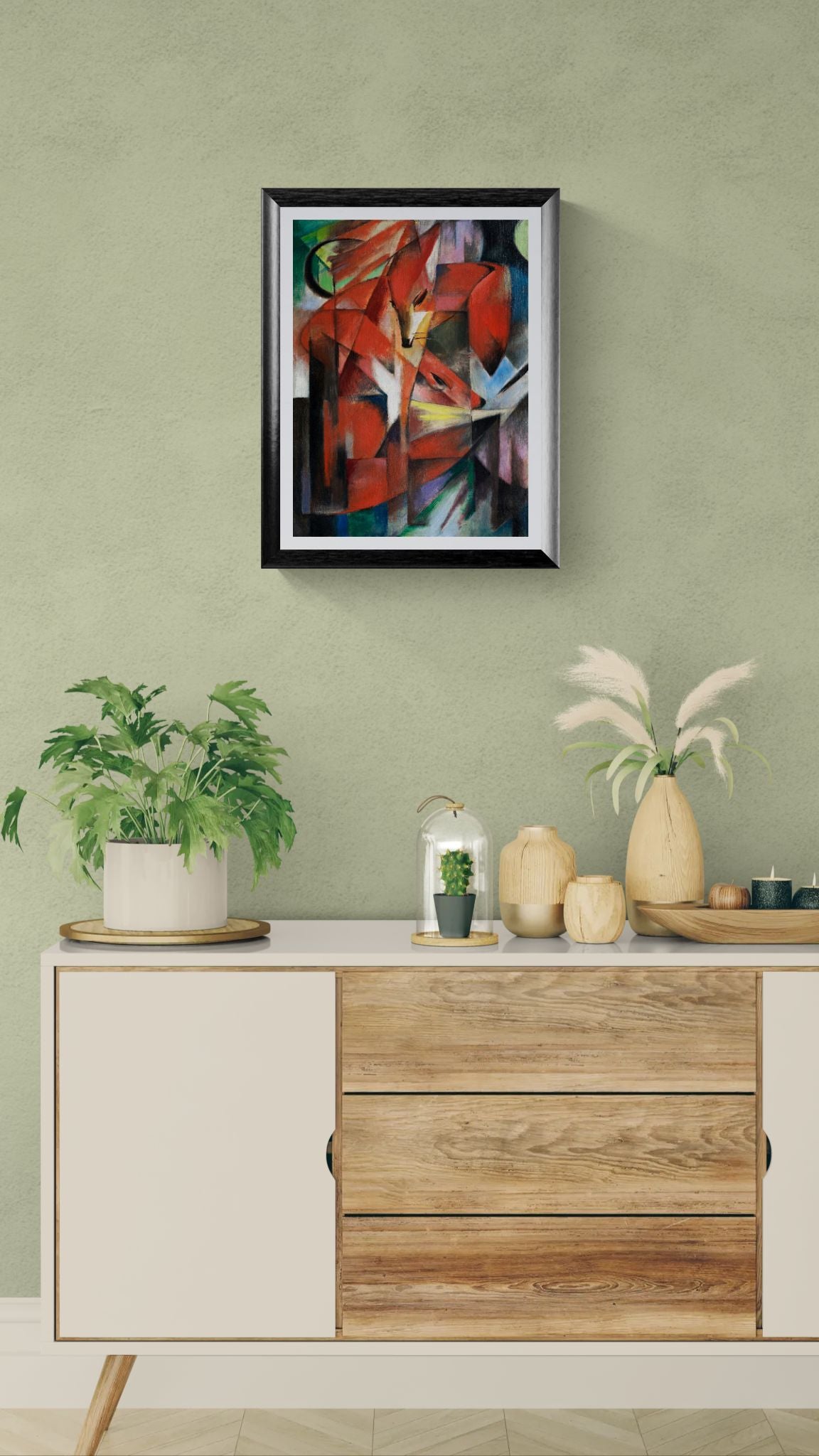 Framed abstract painting on a wall above a wooden cabinet with decorative items.