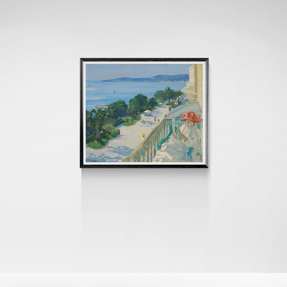 Framed artwork of a coastal scene with a balcony and ocean view on a white wall.