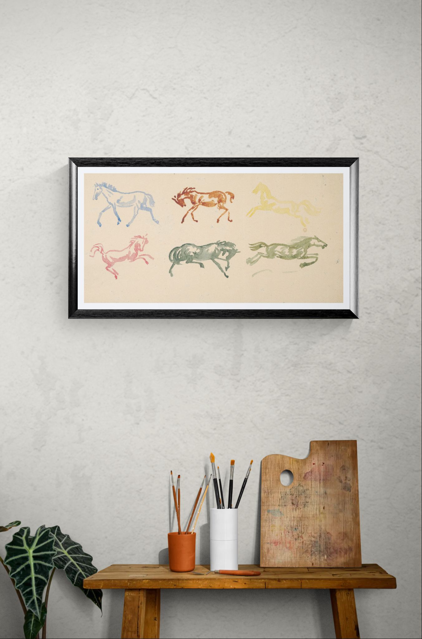 Framed artwork of colorful horse illustrations on a wall above a wooden bench with art supplies.