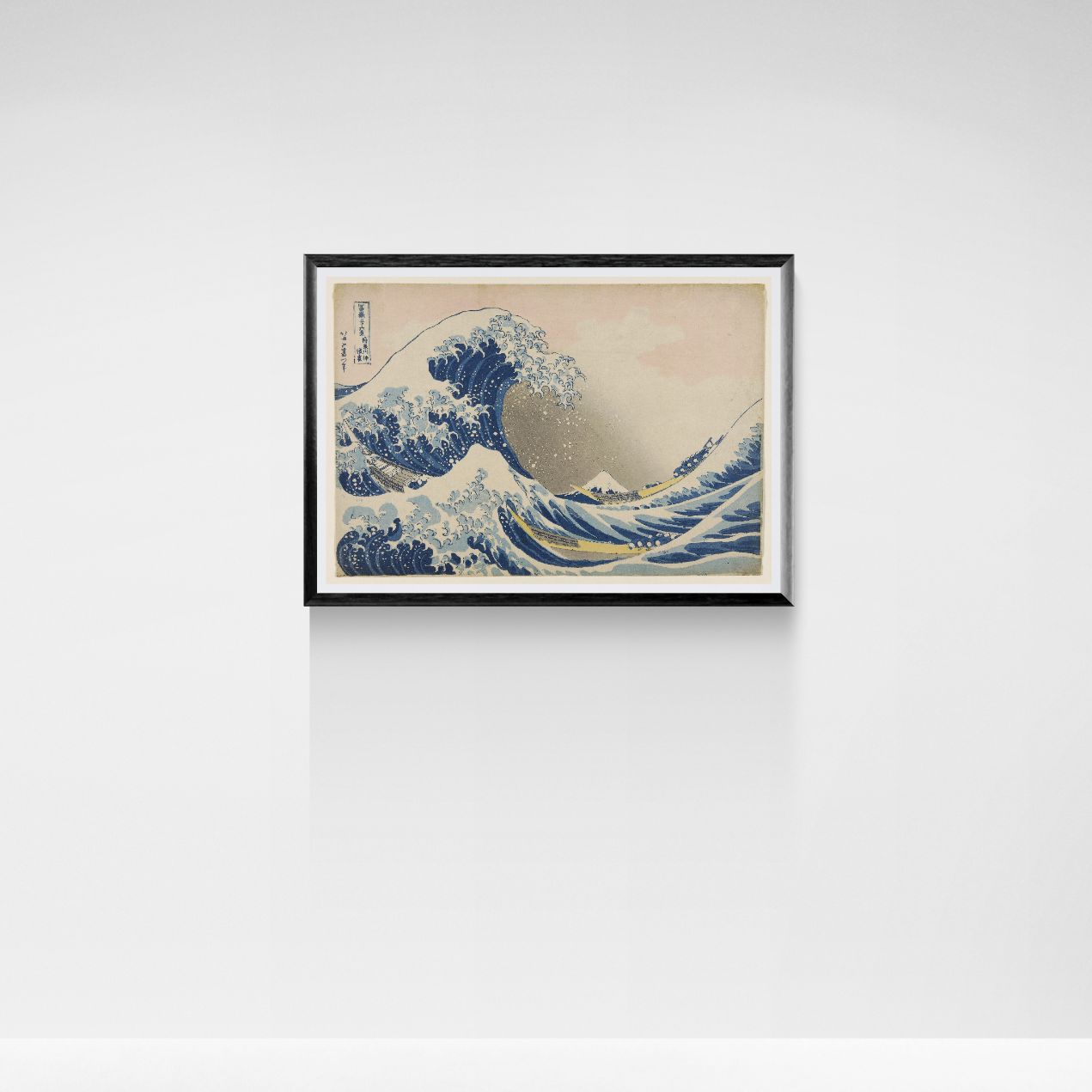 Framed artwork of a wave on a white wall
