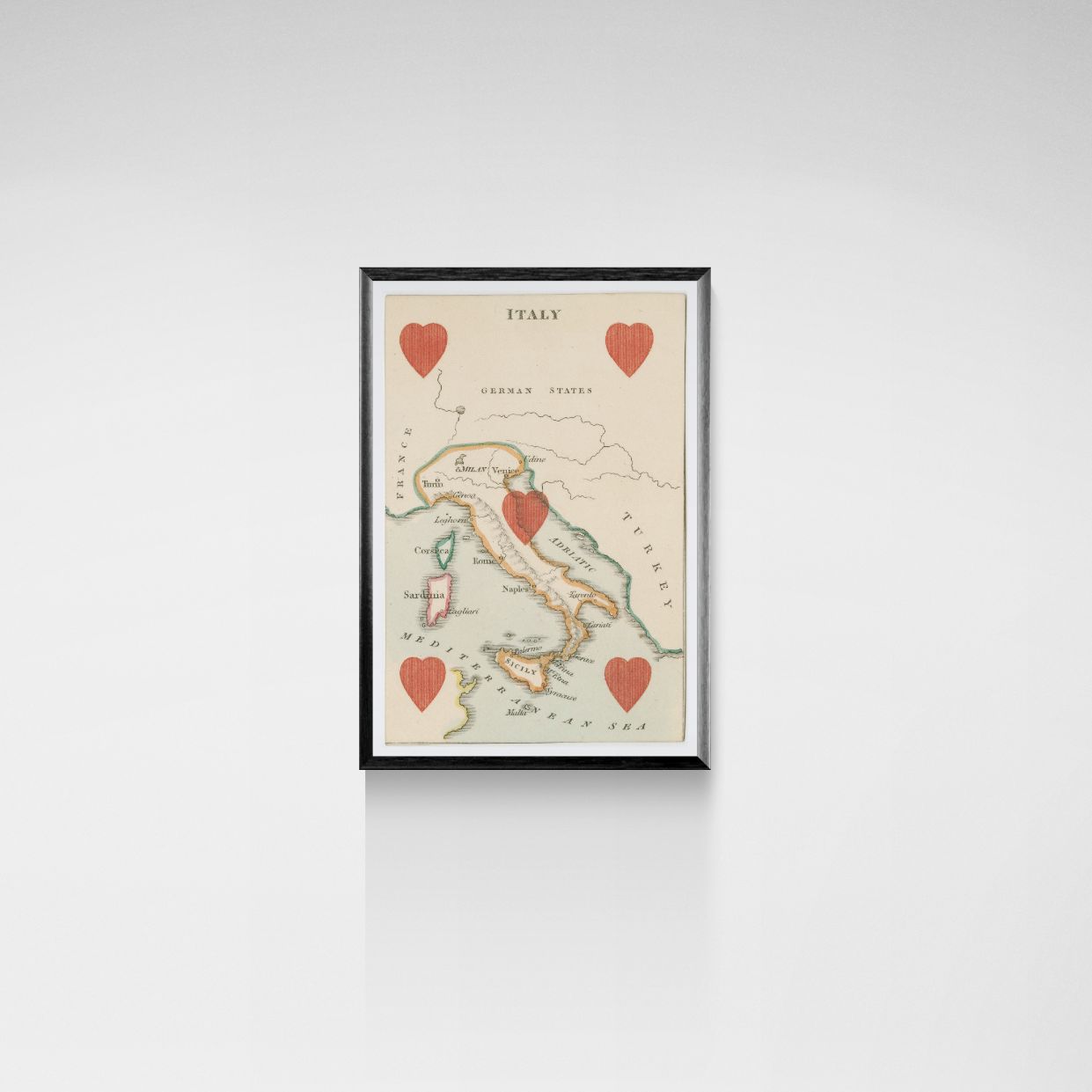 Framed map of Italy with red hearts on a white wall
