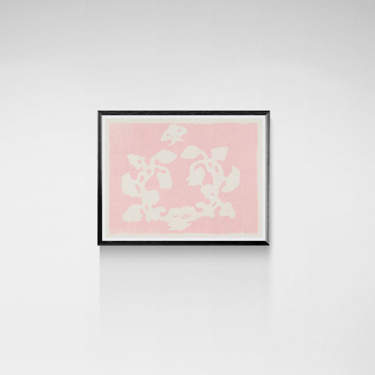 Framed artwork with white floral pattern on a pink background against a white wall