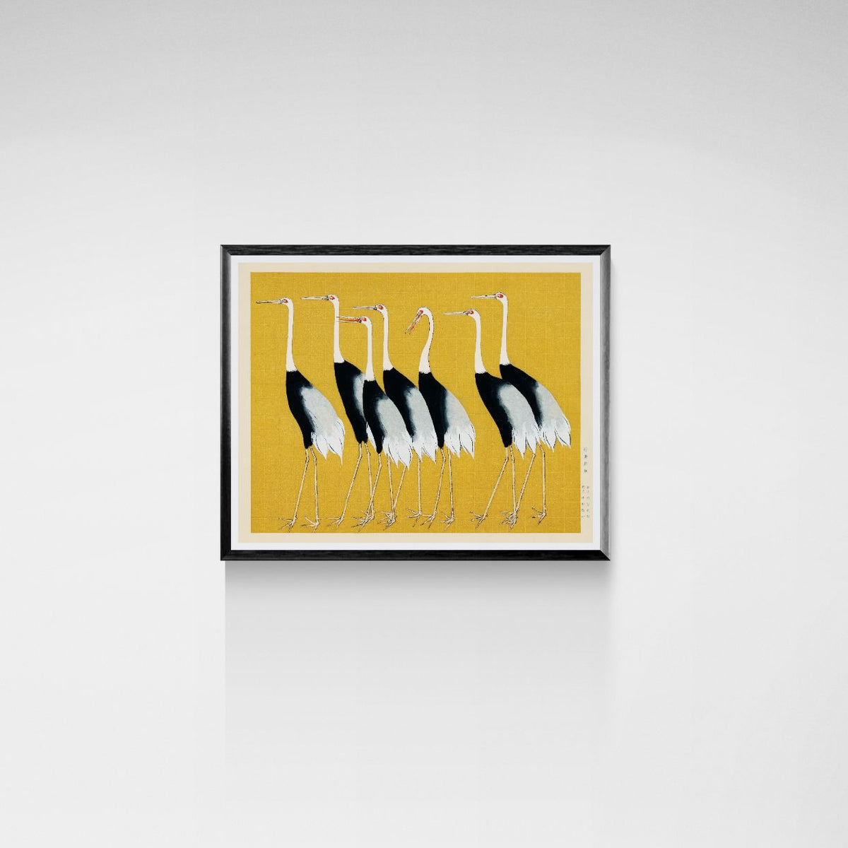 Framed artwork of black and white birds on a yellow background