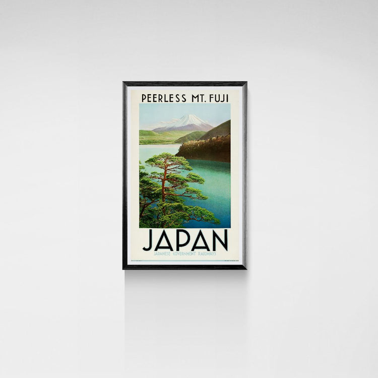 Framed poster of Mount Fuji with a lake and trees on a white wall.
