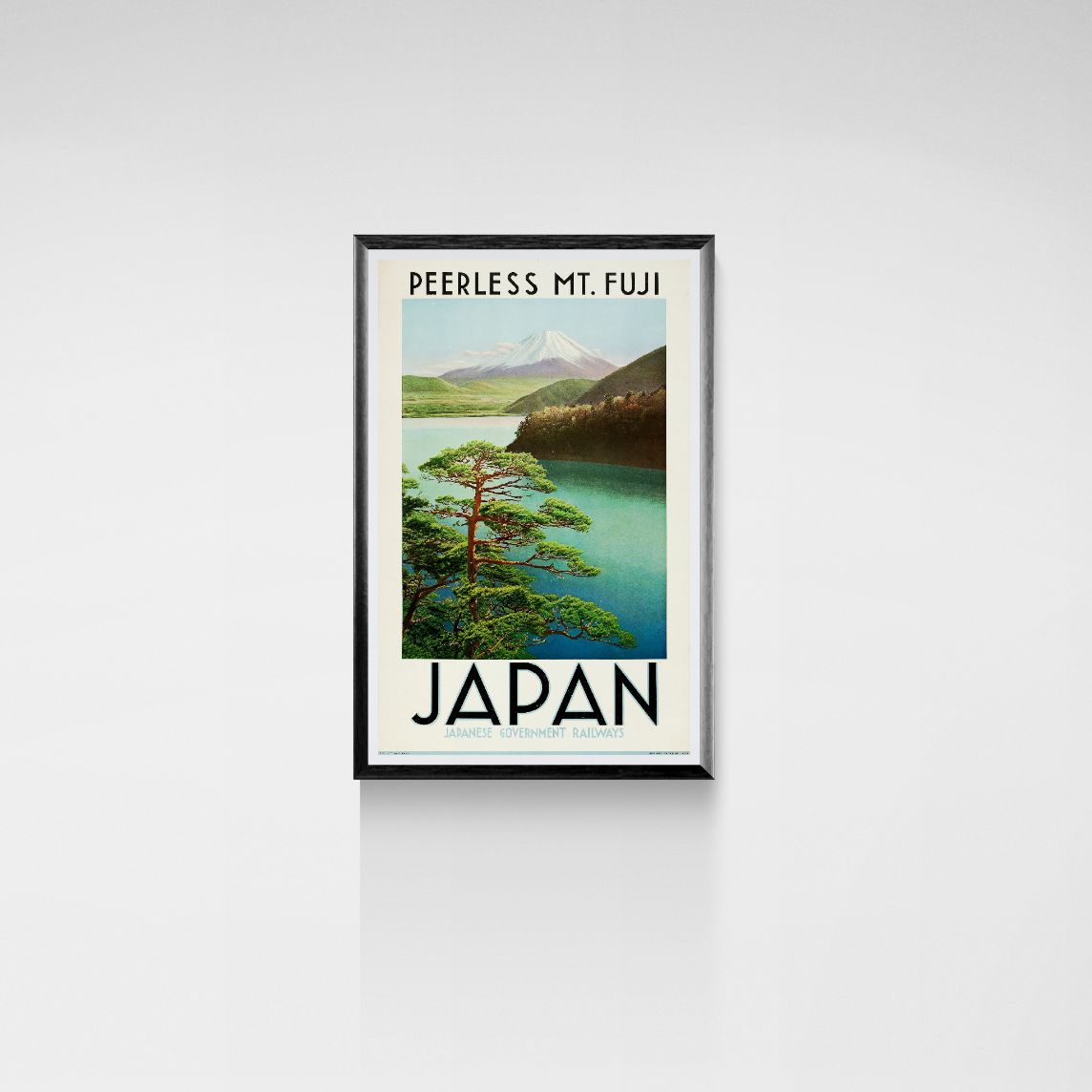 Framed poster of Mount Fuji with a lake and trees on a white wall.