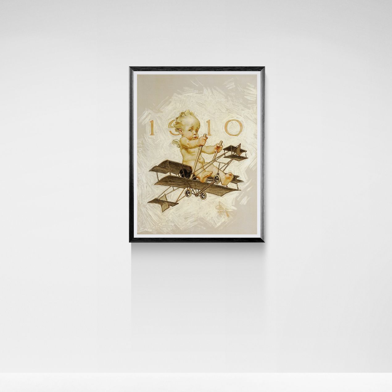 Framed artwork of a cherub on an airplane with '1910' text on a white wall.