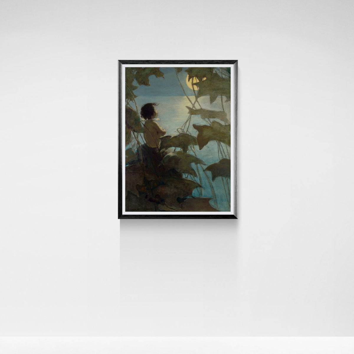 Framed artwork of a person sitting by a body of water with trees, on a white wall.