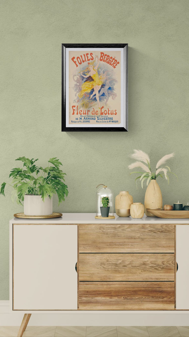 Framed vintage poster on a wall above a wooden cabinet with decorative items.