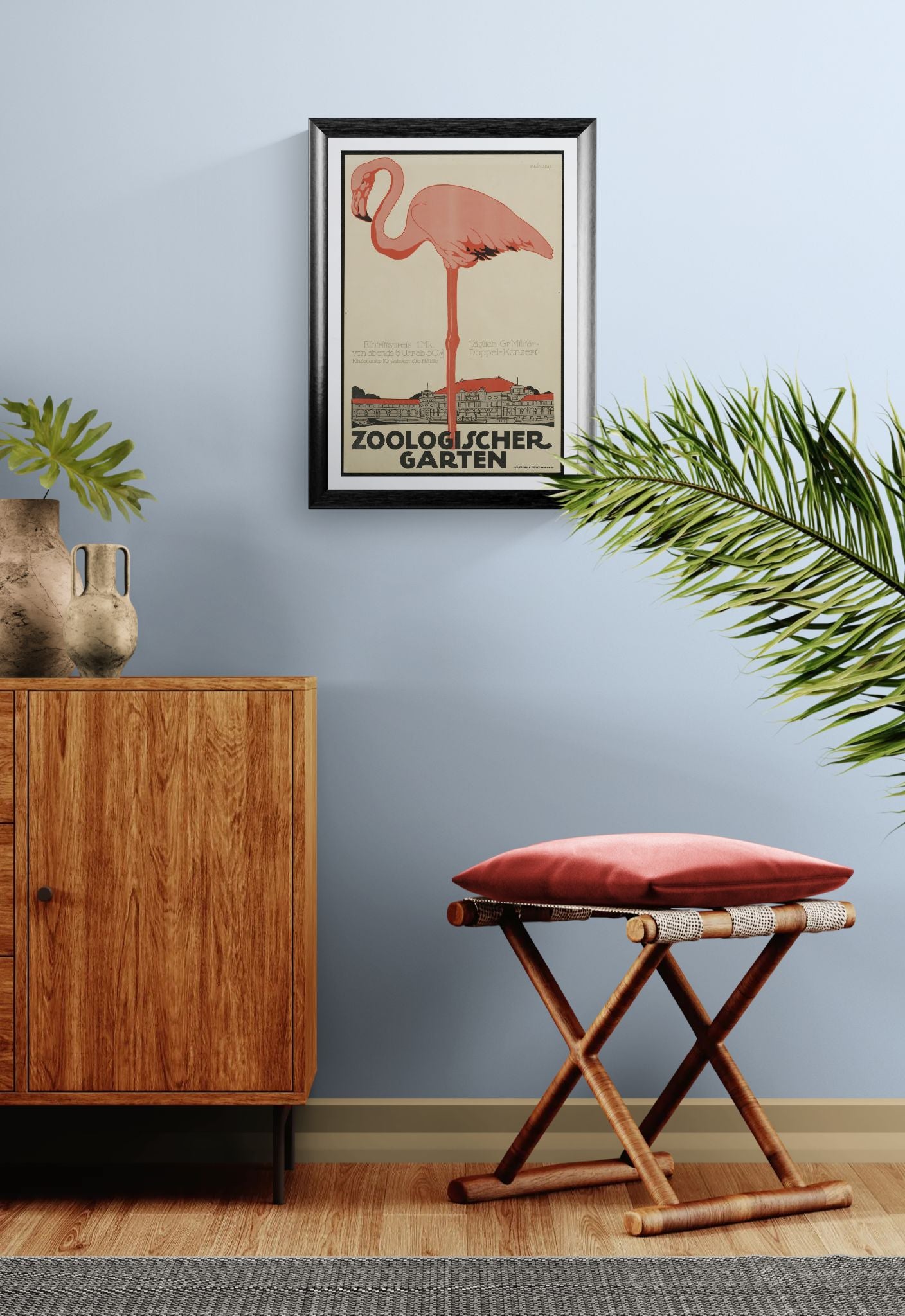 Framed artwork of a pink flamingo on a wall above a wooden cabinet and stool with a red cushion.