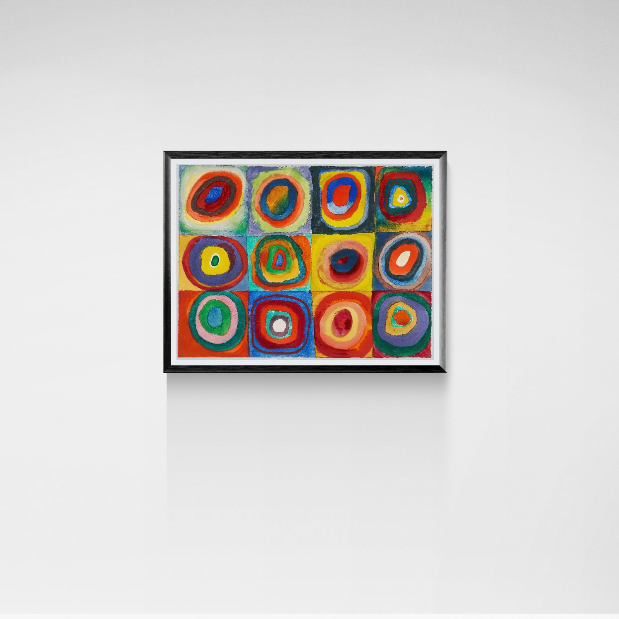 Framed abstract artwork with colorful circles on a white wall