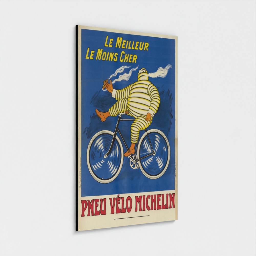 A vintage-style Michelin bicycle poster print shown hanging against a light gray wall. The artwork features a striped yellow-and-white Michelin man riding a bicycle on a blue background, with yellow and red text reading 'Le Meilleur Le Moins Cher' and 'Pneu Velo Michelin'.