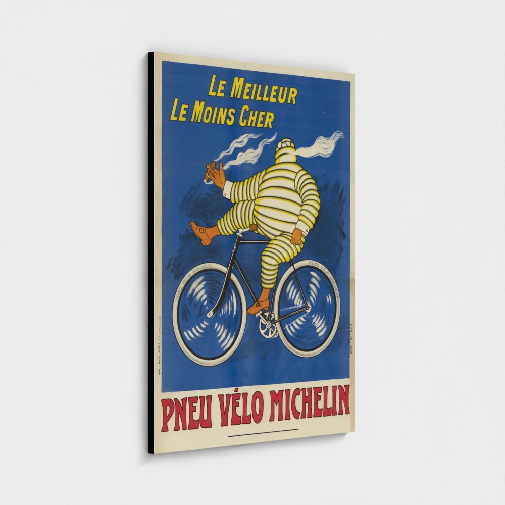 A vertical vintage-style Michelin bicycle poster mounted on a light gray wall. The poster features a cyclist in a yellow-and-white striped suit riding a bicycle against a blue background, with French text reading 'Le Meilleur Le Moins Cher' at the top and 'Pneu Vélo Michelin' at the bottom.