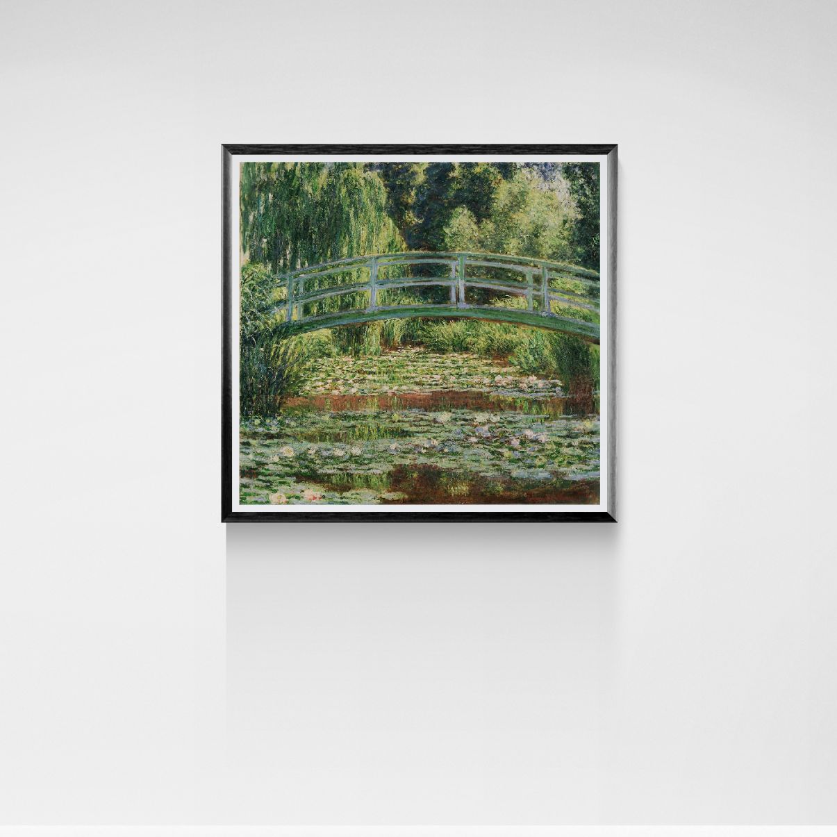 Framed artwork of a bridge over water lilies on a white wall