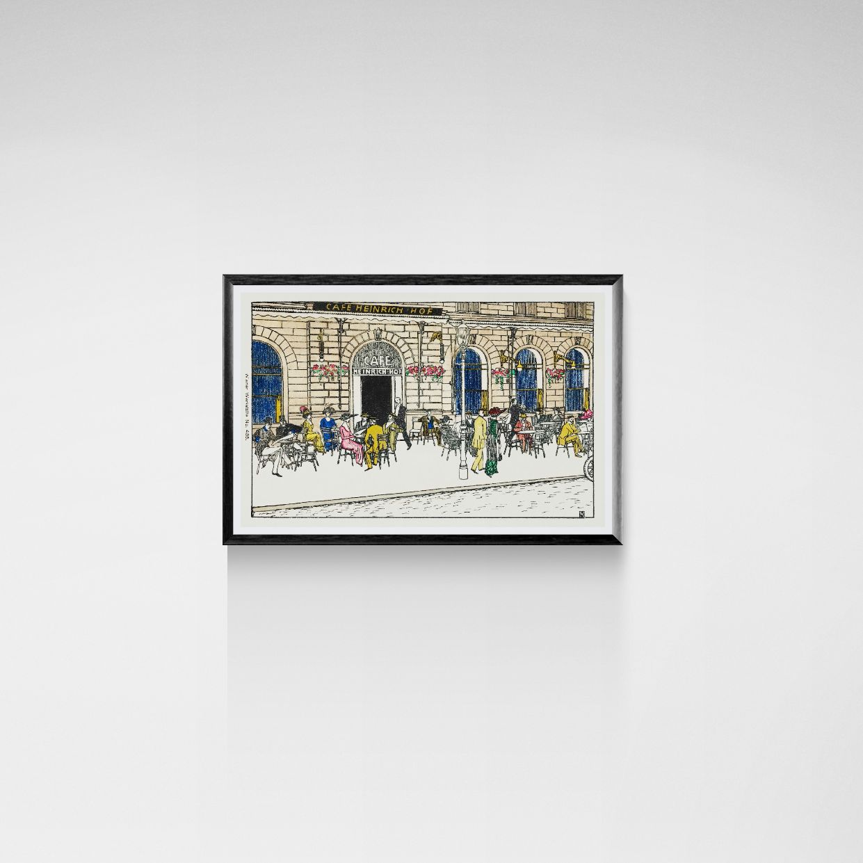 Framed artwork of a city street scene with people on a white wall