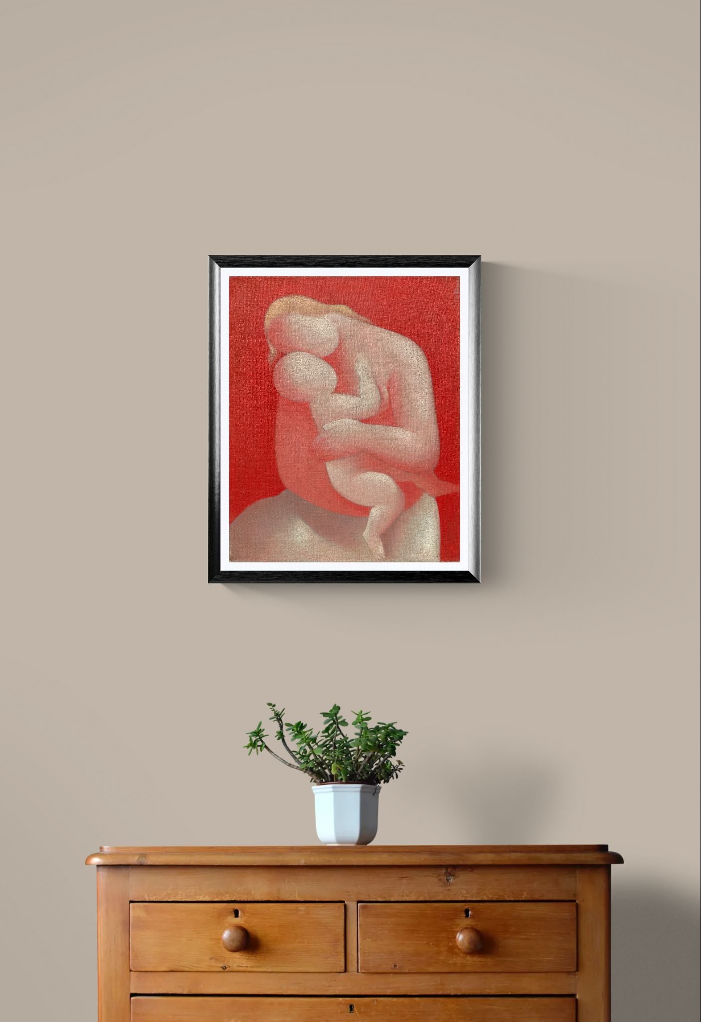 Framed artwork of a nude figure on a red background above a wooden dresser with a plant.