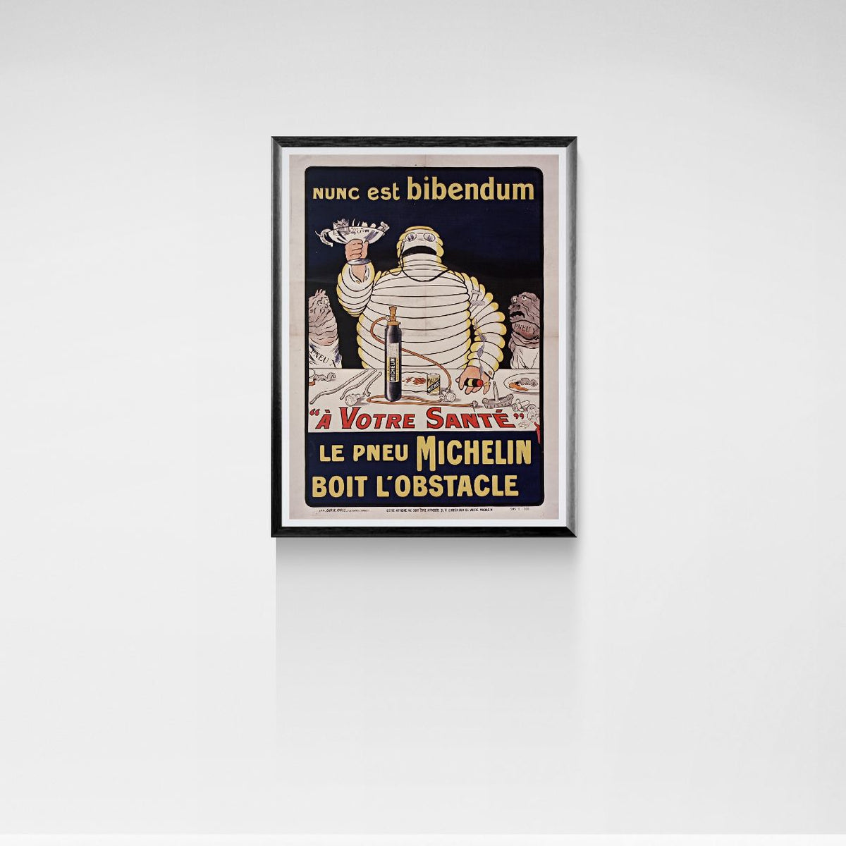 Framed vintage poster of Michelin Man on a white wall