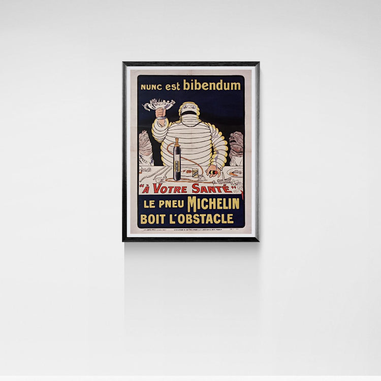 Framed vintage poster of Michelin Man on a white wall