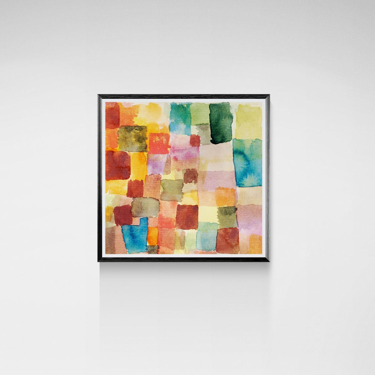 Framed abstract artwork with colorful square patterns on a white wall.