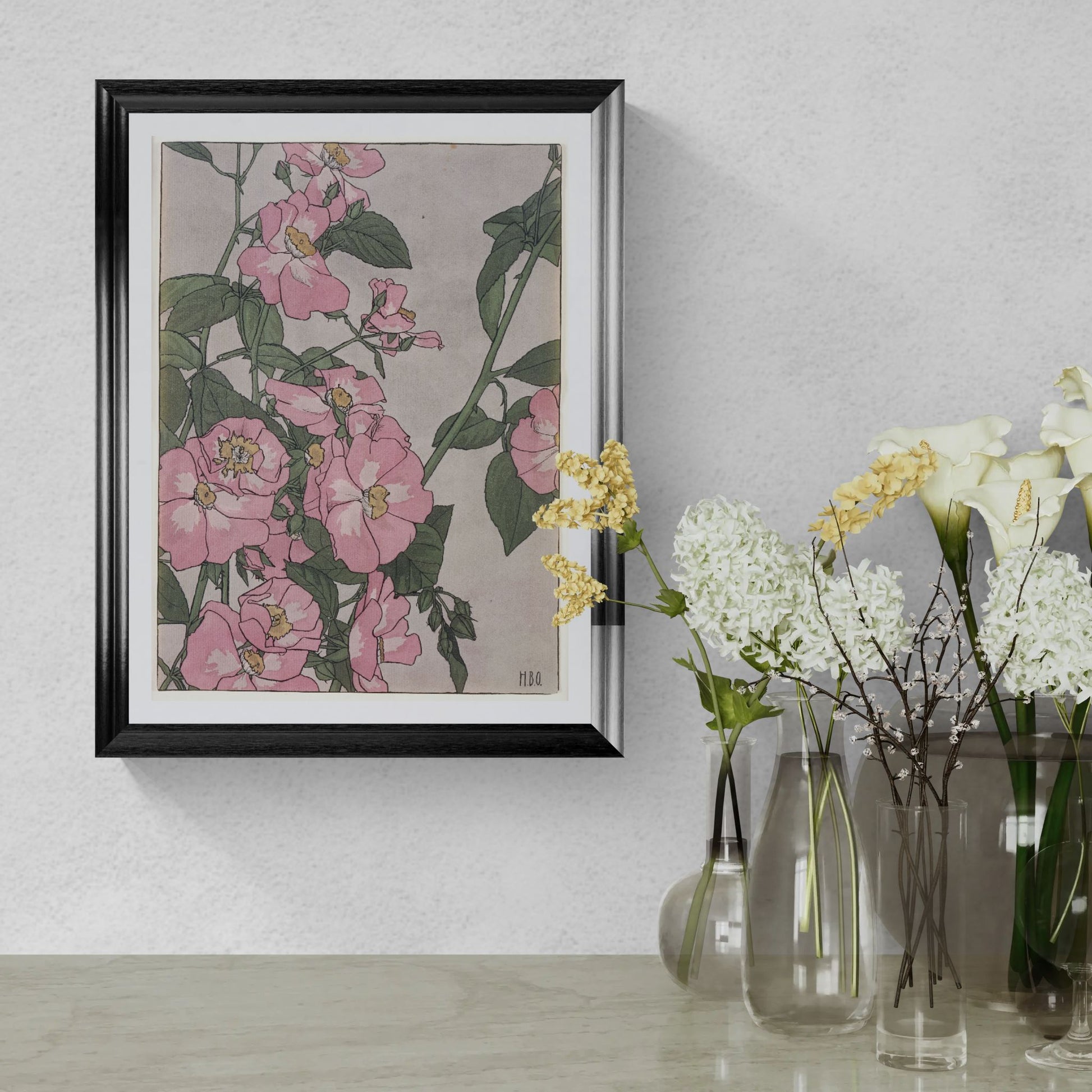 Framed floral artwork on a wall with decorative vases below.