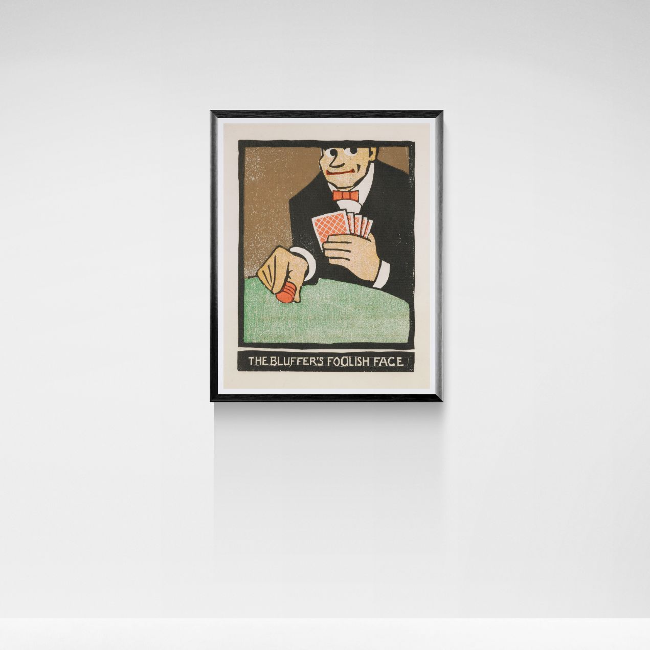 Framed artwork of a man holding playing cards on a white wall