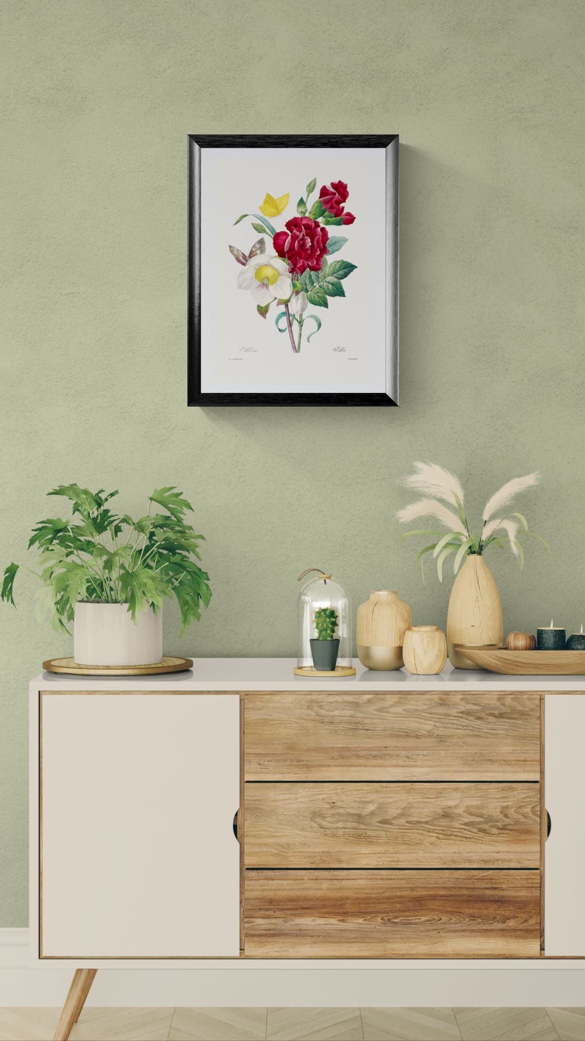 Decorative setup with a framed floral print above a wooden cabinet against a green wall.