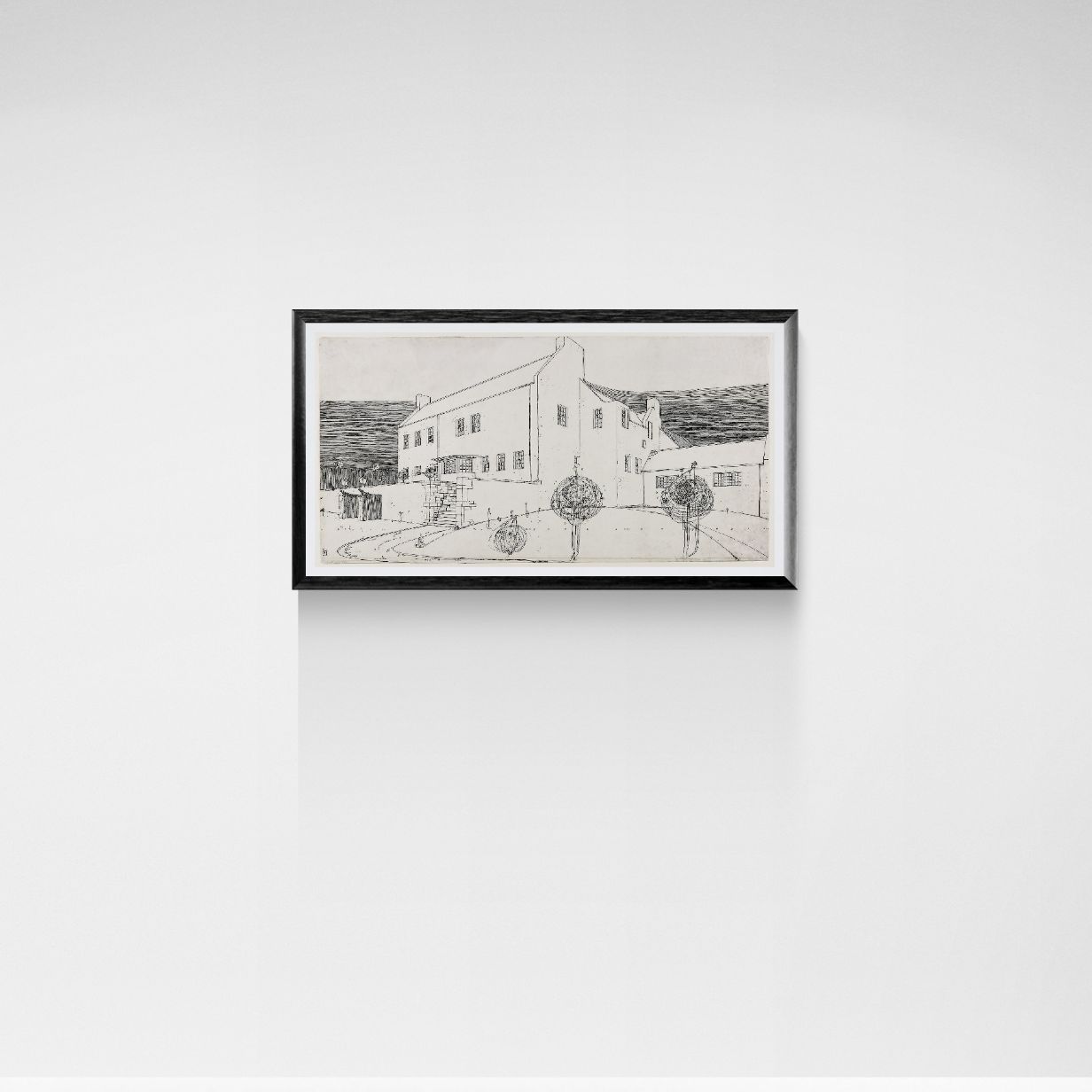 Framed black and white drawing of a building on a white wall