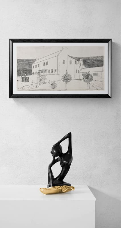 A framed black and white architectural sketch of a building hangs on a light gray textured wall above a white pedestal. The frame is black with a white mat, and a black abstract figurative sculpture with a gold base sits on the pedestal below.