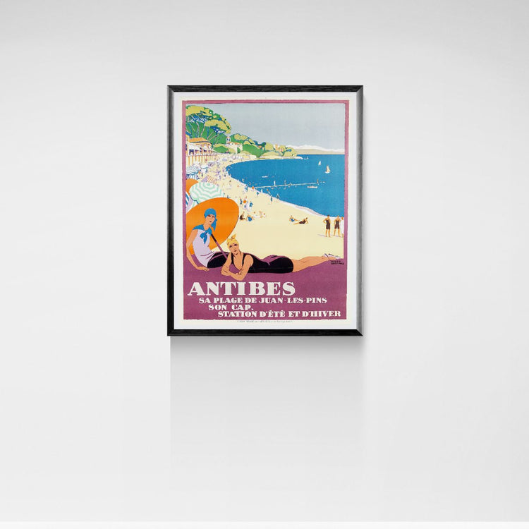 Framed poster of a beach scene with people and text 'Antibes' on a white wall.
