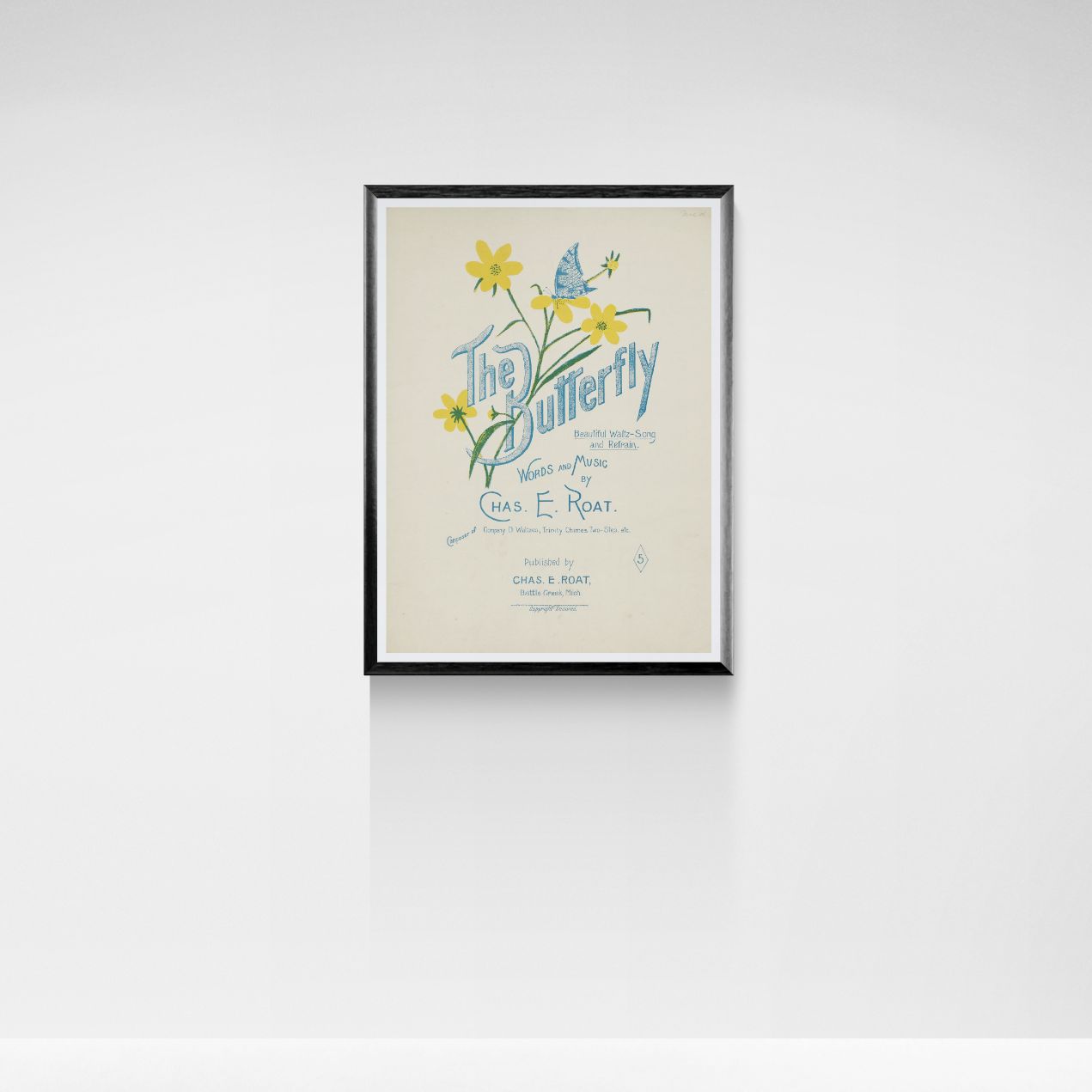 Framed poster of 'The Butterfly' with floral design on a white wall