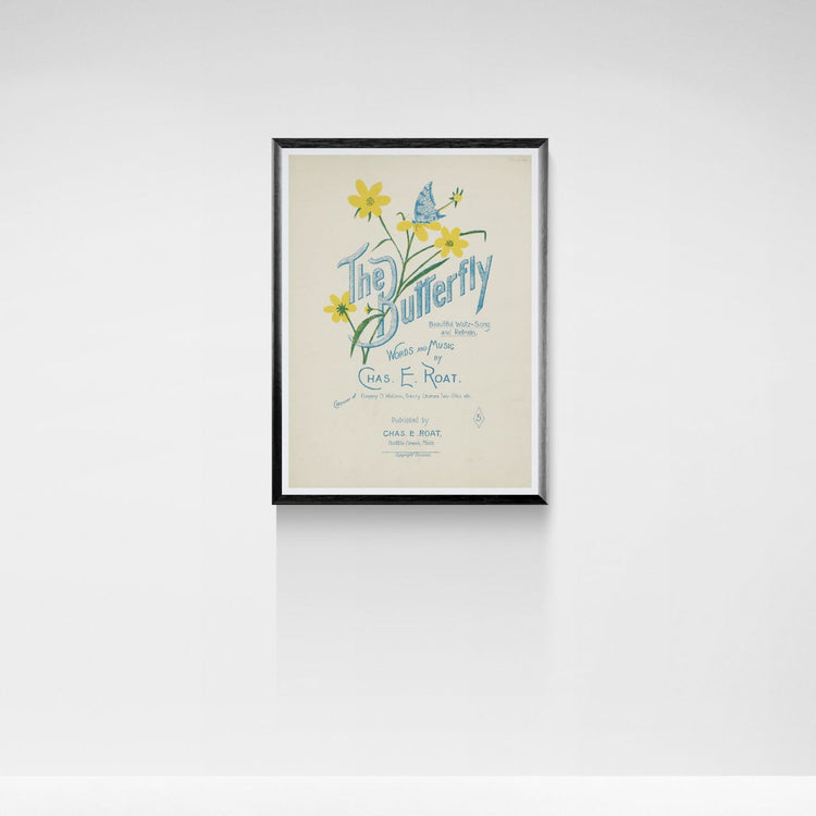Framed poster of 'The Butterfly' with floral design on a white wall